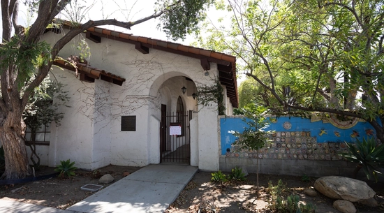 Image of a white building with trees around it.