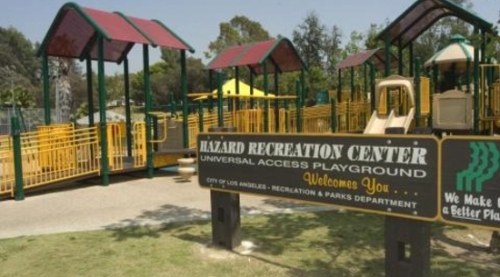 A view of a sign that says "Hazard Recreation Center" next to a playground in Hazard Recreation Center.