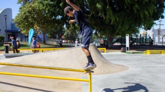 View of a person on a skateboard grinding a rail in Lake Street Skate Park. 